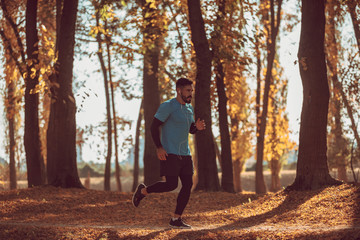 Obraz premium Handsome man running in the forest.