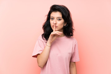 Young woman over isolated pink background doing silence gesture