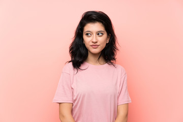 Young woman over isolated pink background standing and looking to the side