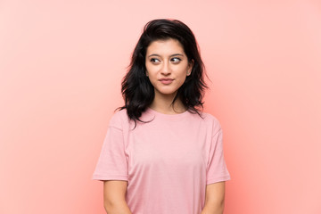 Fototapeta premium Young woman over isolated pink background standing and looking to the side