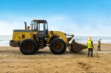 Bulldozers clean up trash on the beach