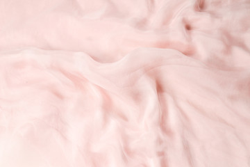 Soft smooth pink silk fabric background. Fabric texture.