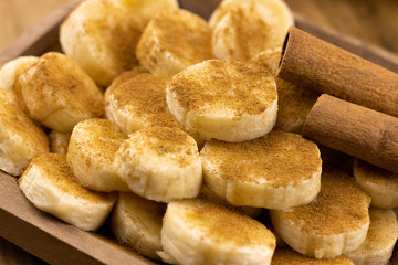 banana slices with cinnamon sprinkled on top and cinnamon sticks - Powered by Adobe