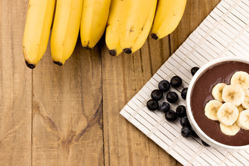 acai bowl beaten with acai and bananas on wooden table top view