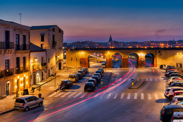 The long light trails from the cars passing in the centre of an anciant city