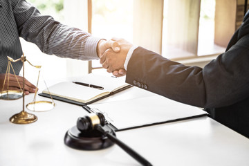 Successful agreement, Justice lawyer hand shaking with Client in courtroom.