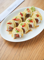    Japanes rice roll with salmon and lemon toped on the white plate