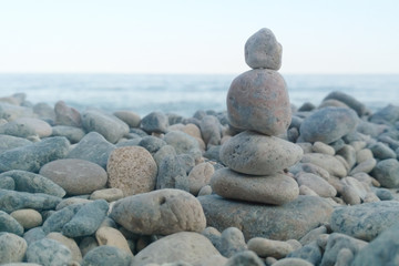 Fototapeta na wymiar Little cairn on the background of the sea. Landscape for meditation. Pebbles on the sea coast.