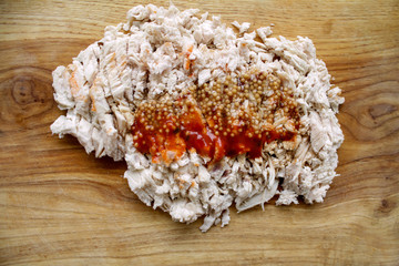 boiled chicken sliced on a board with sauce and spices