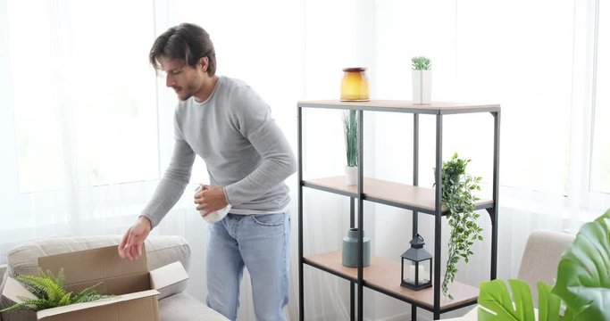 Young man dancing while unboxing and decorating his new house