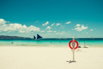 Lifesaver equipment on tropical white sand paradise beach. Red lifebuoy. Life insurance helping concept. Travel to Philippines. Boracay seascape. Water activities. Luxury holiday resort. Copy space