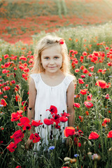 a girl smiles among poppy flowers