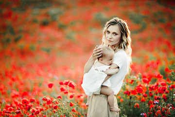 a mother holds and leans her baby