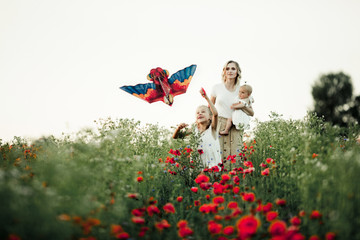 a girl is playing with a toy, her mother with baby look at her