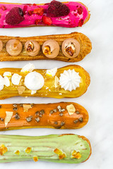 Artisan French Eclairs Decorated, Top View on White Marble