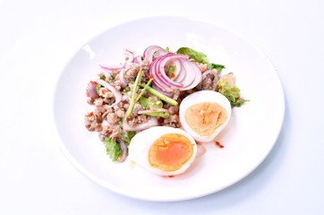 boiled egg half cutting topping sour and spicy minced pork salad on plate