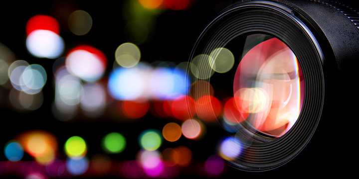 a photographic lens and city street lights bokeh