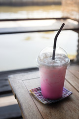 Iced pink milk in plastic cup.