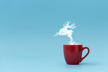 Steam in reindeer shape flying from coffee cup. Morning drink. Christmas or New Year celebration concept. Copy space.