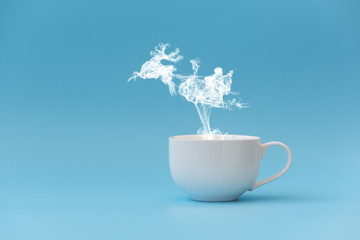 Steam in reindeer and Santa Claus into sled shape flying from coffee cup. Morning drink. Christmas or New Year celebration concept. Copy space.