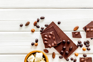 Cook homemade chocolate with bars, nuts, coffee beans on white wooden background top view mock up
