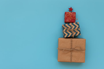 Gift boxes in Christmas fir tree shape on blue background. Flat lay. Christmasr gift packing. Christmas or New Year celebration concept. Copy space.