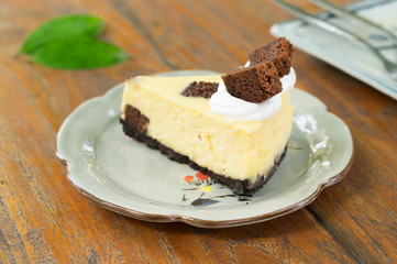 Cheese cake with chocolate and cream on top.