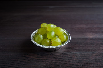 grape berries in a plate on a dark background