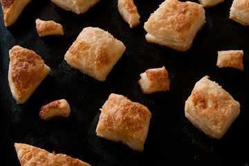 puffs of dough sprinkled with sugar on a baking sheet