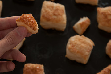 puffs of dough sprinkled with sugar on a baking sheet
