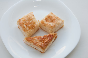 puffs of dough sprinkled with sugar on a white plate