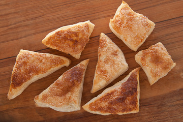 puffs of dough sprinkled with sugar on a wooden tray