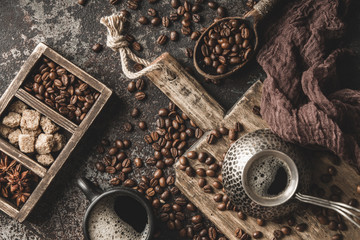 Coffee on wooden board with coffee beans on dark textured background. Top view with copy space. Background with free text space.