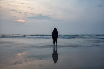 Attraktive Frau steht allein am Strand