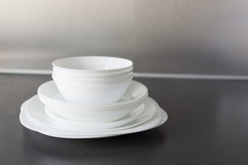 Set of fresh washed plates and cutlery on the kitchen table.