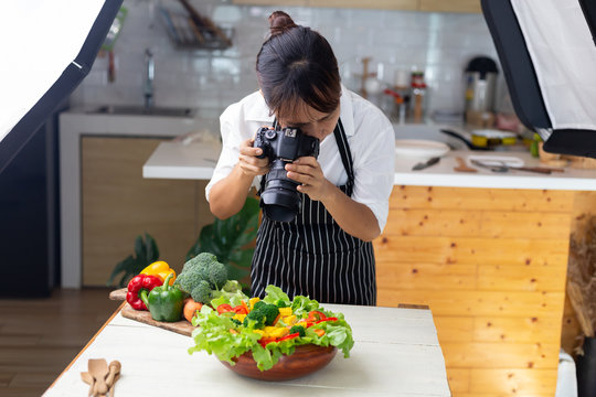 photographer food , asian women is taking pictures of food her food in studio.