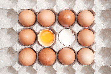 Top view egg yolk among other egg in carton box background