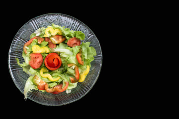 Dish of salad on black background