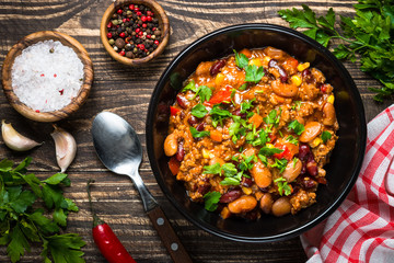 Chili con carne from meat and vegetables on wooden table top vie