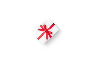 Top view of white gift box with red ribbon on white isolated background.