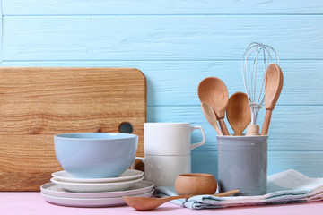 Fototapeta na wymiar A set of dishes and kitchen utensils on a colored background.