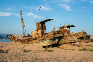 Beautiful sunrise on an old wooden fishing boat on the beach