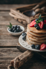 American pancakes with fresh berry on wood background. Summer homemade breakfast.