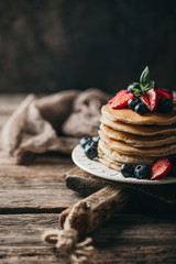 American pancakes with fresh berry on wood background. Summer homemade breakfast.