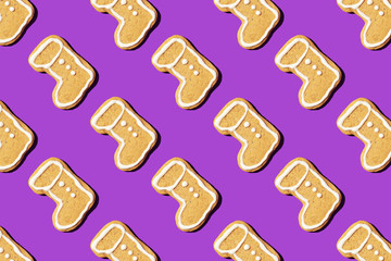 Christmas gingerbread pattern on violet background. Top view. Flat lay. Boot shapes cookies. New year and Christmas concept