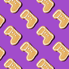 Christmas gingerbread pattern on violet background. Top view. Flat lay. Boot shapes cookies. New year and Christmas concept