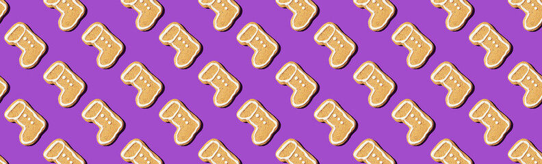 Christmas gingerbread pattern on violet background. Top view. Flat lay. Boot shapes cookies. New year and Christmas concept