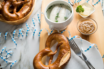 Münchener Weißwurst in Terrine mit bayrischer süßen Senf, Brezel und Butter auf Holz Brett bei...