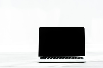 modern laptop with blank screen on wooden table on white