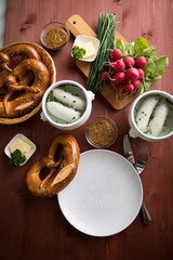 Münchener Weißwurst in Terrine mit bayrischer süßen Senf, Brezel, Radieschen, Schnittlauch und Butter auf Holz Tisch